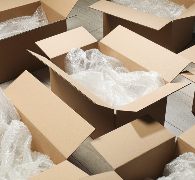 Many,Open,Cardboard,Boxes,With,Bubble,Wrap,On,White,Wooden