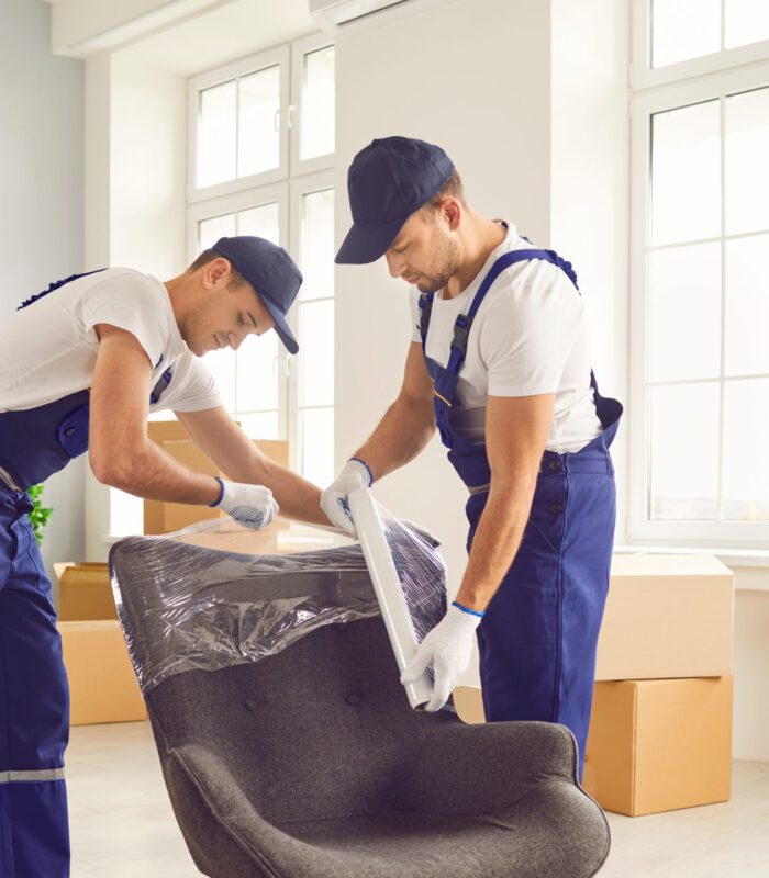 Portrait,Of,A,Two,Young,Smiling,Male,Movers,Packing,Furniture